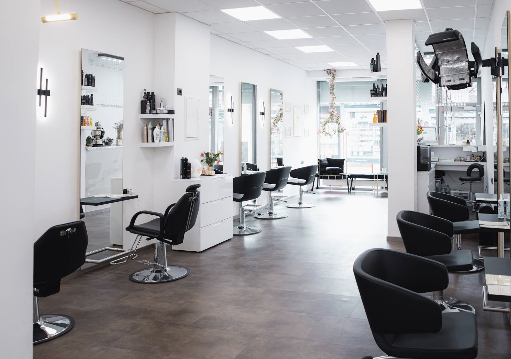 Blick in den Salon von MadoFarah Beauty in Frankfurt-Höchst: schwarze Friseurstühle vor hohen Spiegeln an weissen Wänden.